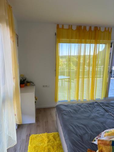 a bedroom with a bed and a large window at Guest House BiBi-Lux in Ilsfeld