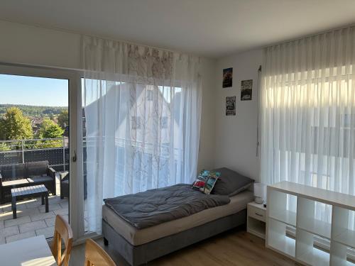 a bedroom with a bed and a balcony at Guest House BiBi-Lux in Ilsfeld