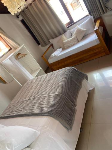a small bedroom with a bed and a window at Pousada Aky Jeri in Jericoacoara