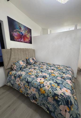 a bedroom with a bed with a floral comforter at Hôtel Garden's jacuzzi spa 1 in Brussels