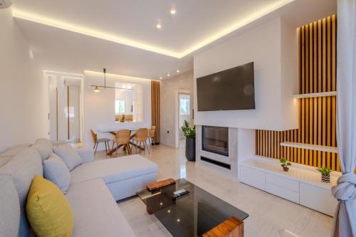 a living room with a couch and a tv at Azure7 Seaside - Luxury Apartment in Varkiza in Vari