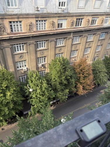 a large building with trees in front of it at Apartments Sat in Belgrade