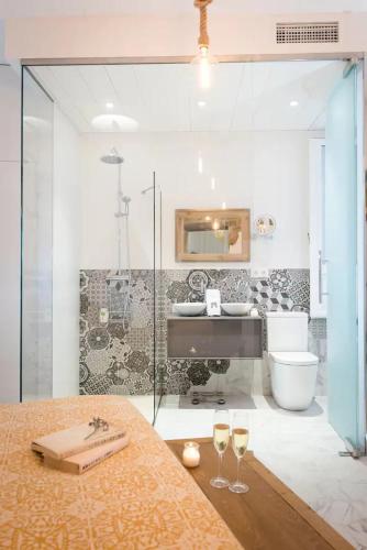 a bathroom with a glass shower and two wine glasses at Santo Copas in Seville