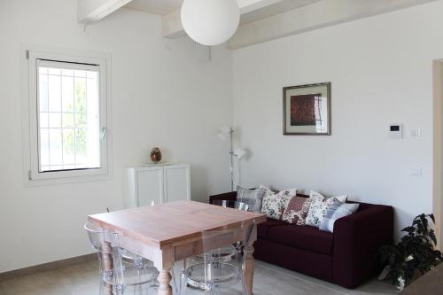 a living room with a table and a couch at Casa Fiorita in Castel Bolognese