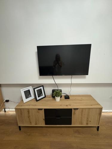 a wooden coffee table with a flat screen tv on a wall at Apartments Sat in Belgrade