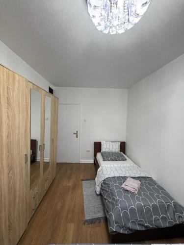 a bedroom with two beds and a chandelier on the ceiling at Apartments Sat in Belgrade