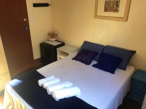 a bedroom with a bed with towels on it at Quarto Cama Casal Domingos Martins in Domingos Martins
