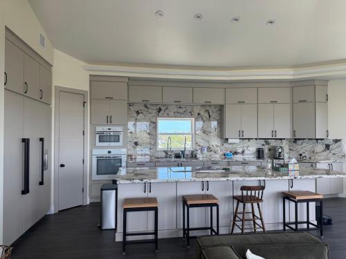 a kitchen with white cabinets and bar stools at Il Capitano - Little Torch Key in Little Torch Key