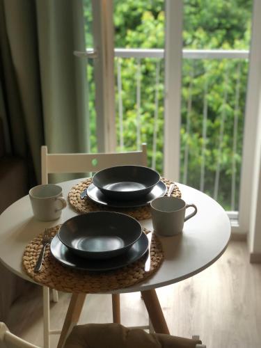 a table with two plates and two cups on it at Apartment Prague Airport- 5 minute drive from AirPort in Tuchoměřice