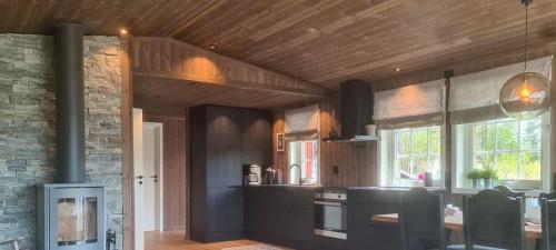 a kitchen with a stove and a table in it at Renovated Cabin By Lake Djupedal in Bygstad