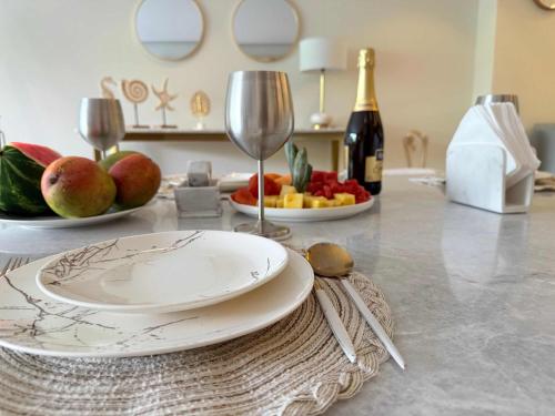 a table with a plate and a wine glass at Bolongo 2BR your exclusive oceanfront escape in Punta Mita