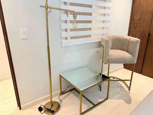 a chair and a glass table and a lamp at Bolongo 2BR your exclusive oceanfront escape in Punta Mita
