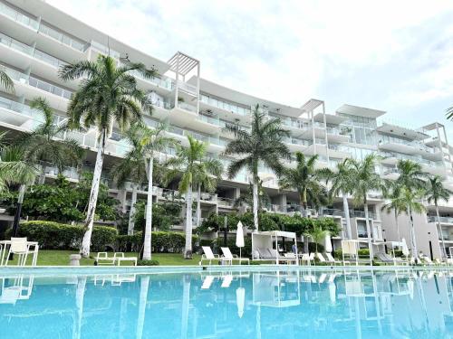 a large hotel with a swimming pool and palm trees at Bolongo 2BR your exclusive oceanfront escape in Punta Mita