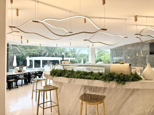 a restaurant with a bar with stools and tables at Bolongo 2BR your exclusive oceanfront escape in Punta Mita