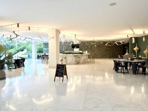 a large room with tables and chairs and a sign at Bolongo 2BR your exclusive oceanfront escape in Punta Mita