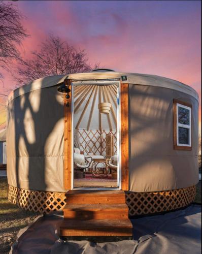 a round tent with a bed and a chair in it at Boho Bliss Yurt - Unit # 4 in Woodway