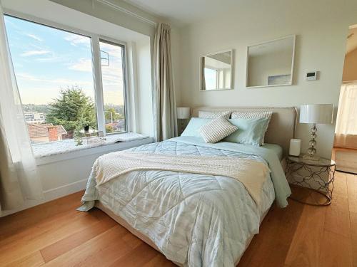 a bedroom with a bed and a large window at Roger & May's Cabin in Vancouver