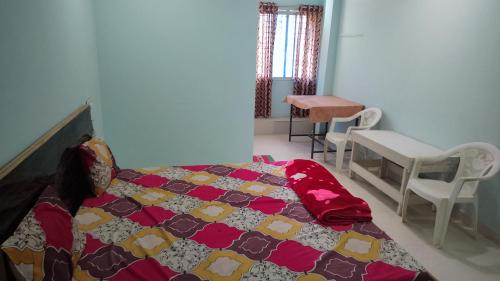 a bedroom with a bed and a table and chairs at AG HOTEL sdl in Shahdol