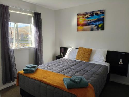 a bedroom with a large bed with a window at LAKE ESCAPE - Brand new warm and quiet two bedroom Apartment in Otematata