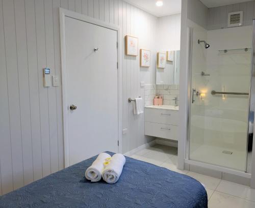 a bathroom with a shower and a bed with towels at Central Private Bedroom & Ensuite - City & Strand Beach Location in Townsville