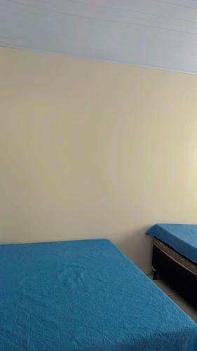 a bedroom with two beds with blue sheets at Casas Paradisiaca Pagamento Automática in Caldas Novas
