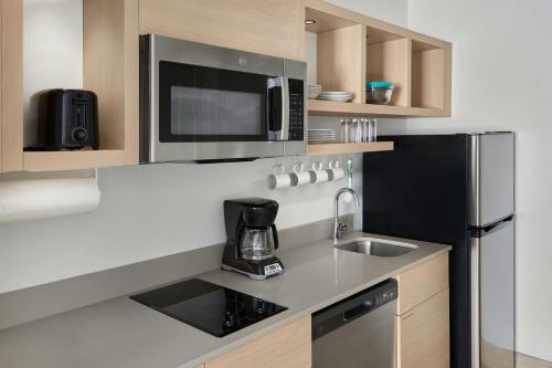 a kitchen with a sink and a microwave at TownePlace Suites by Marriott Lansing North in Lansing