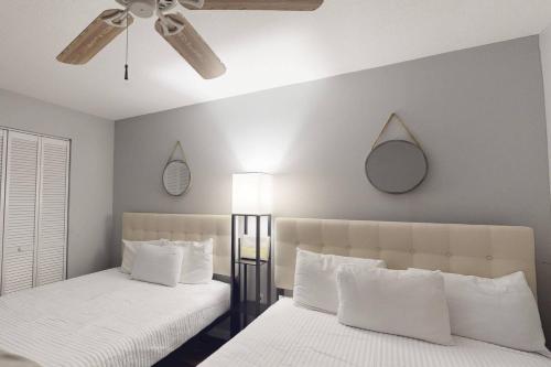 a bedroom with two beds and a ceiling fan at 103 - La Coquina in St Pete Beach