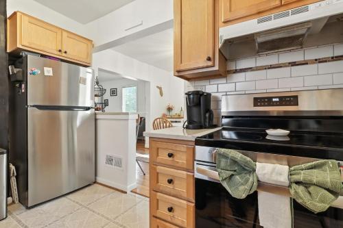 a kitchen with a stainless steel refrigerator and wooden cabinets at La Casa Naranja home in Ann Arbor