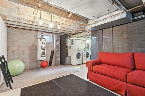 a living room with a red couch and washing machines at La Casa Naranja home in Ann Arbor