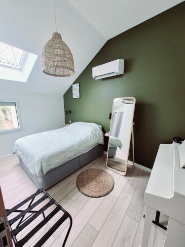 a bedroom with a bed and a green wall at Appartement Spa et Terrasse in Dijon