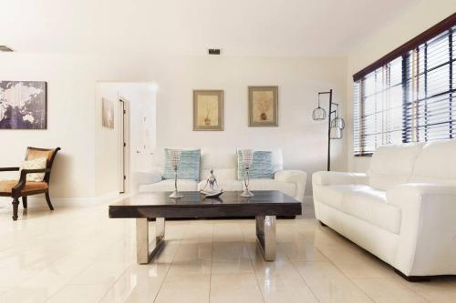 a living room with a white couch and a coffee table at Casa Bugambilia near Miami Airport in Miami
