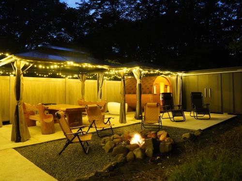 a tent with a fire in a yard at night at 八ヶ岳ココの家 in Hokuto
