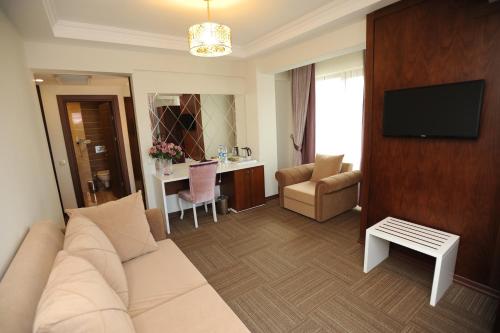 a living room with a white couch and a television at Vurna Butik Hotel in Trabzon