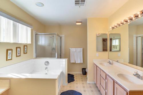 a bathroom with a tub and a sink and a mirror at 4 Mi to Las Vegas Strip Home with Covered Patio! in Las Vegas