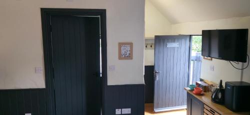 a room with two blue doors and a television at The George and Dragon Pub in Shipley