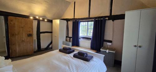 a bedroom with a large white bed with two towels on it at The George and Dragon Pub in Shipley