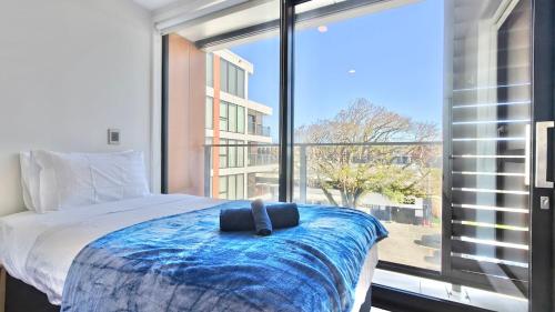 a bedroom with a bed and a large window at Spacious 2-Bedroom, 2-Bathroom Apartment in Epsom in Auckland
