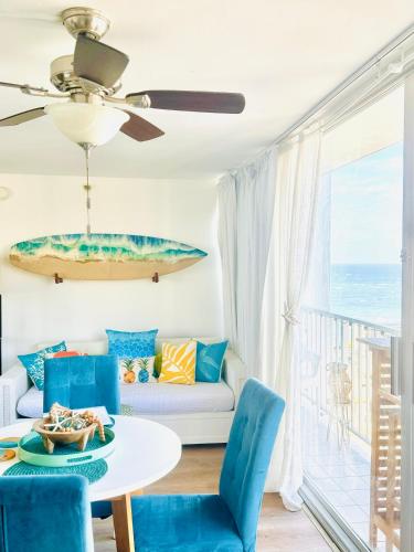 a living room with a table and blue chairs at Sweet Blue Hawaii in Honolulu