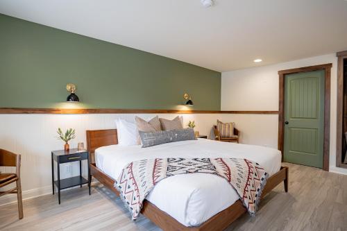a bedroom with a bed and a green wall at Petty Ranch Inn in Springdale
