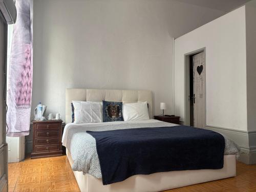 a bedroom with a large bed with a blue blanket at Residência Céu Azul in Porto