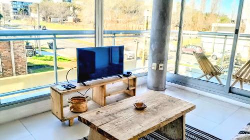 a living room with a tv on a wooden table at Apto 210 Un Refugio luminoso frente a la playa in Colonia del Sacramento