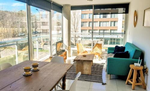 un salon avec une table et des chaises en bois dans l'établissement Apto 210 Un Refugio luminoso frente a la playa, à Colonia del Sacramento
