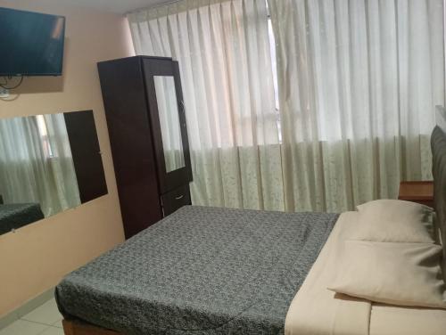 a bedroom with a bed and a mirror and a television at Hotel Chachani cochera 