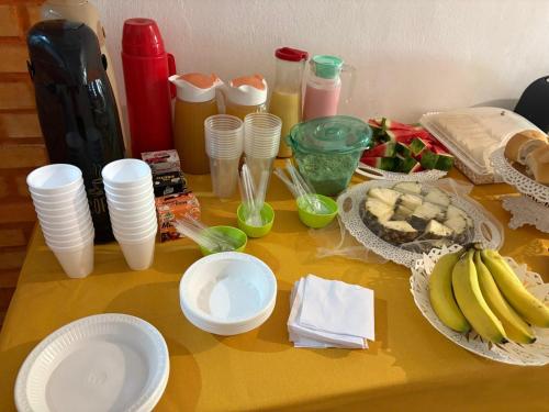 Pousada e Hostel Da Rosa في بيبا: طاولة عليها مجموعة من الأطباق والموز