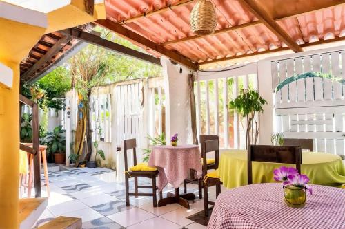 a patio with a table and chairs on a porch at Pousada e Hostel Da Rosa in Pipa