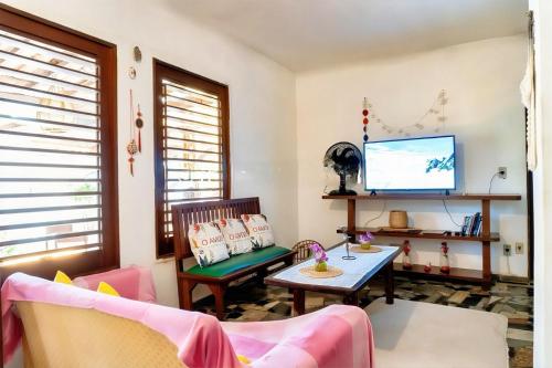 a living room with a tv and a table at Pousada e Hostel Da Rosa in Pipa