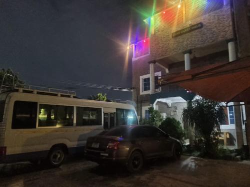 a bus and a car parked next to a building at night at OSAK ROYAL GUEST House in Nsawam