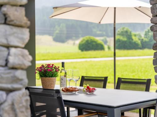 a table with glasses of wine and food on a patio at Mountain Chalet Chapeau in Sankt Lorenzen ob Murau
