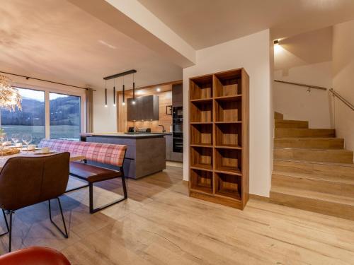 a kitchen and living room with a table and a staircase at Mountain Chalet Krek Wak Wou in Sankt Lorenzen ob Murau