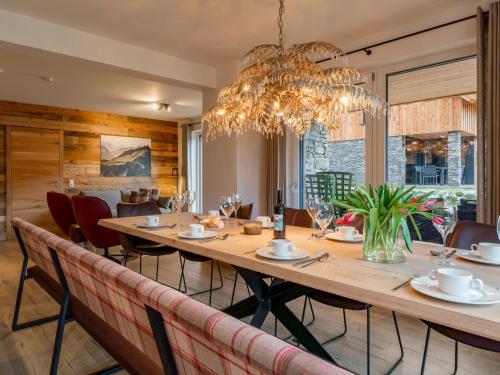 a dining room with a long table and a chandelier at Mountain Chalet Krek Wak Wou in Sankt Lorenzen ob Murau